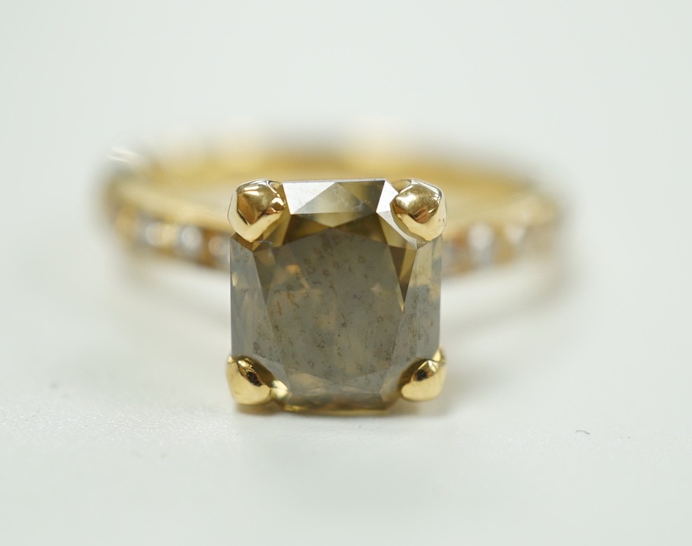 A modern 18ct gold and single stone cut cornered rectangular modified brilliant cut fancy dark brown-greenish yellow diamond, with diamond set shoulders and accompanying GIA report dated 20/12/2013, stating the stone to